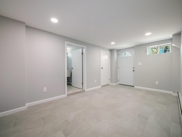 below grade area featuring baseboards, recessed lighting, and baseboard heating