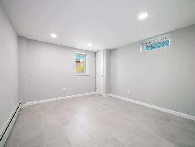 basement featuring a baseboard heating unit, recessed lighting, baseboards, and a healthy amount of sunlight