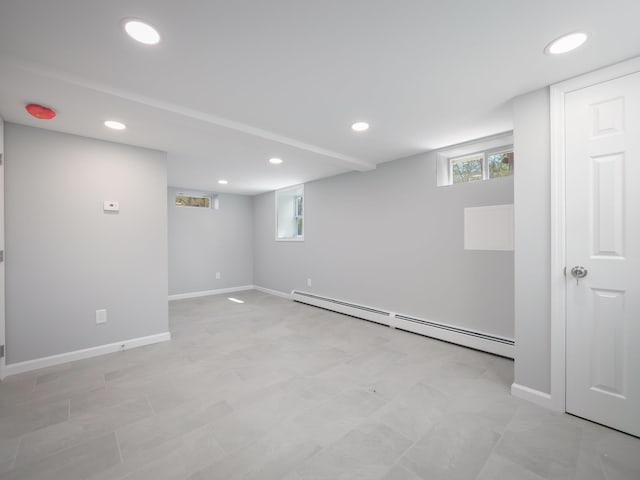 basement with a baseboard radiator, recessed lighting, and baseboards