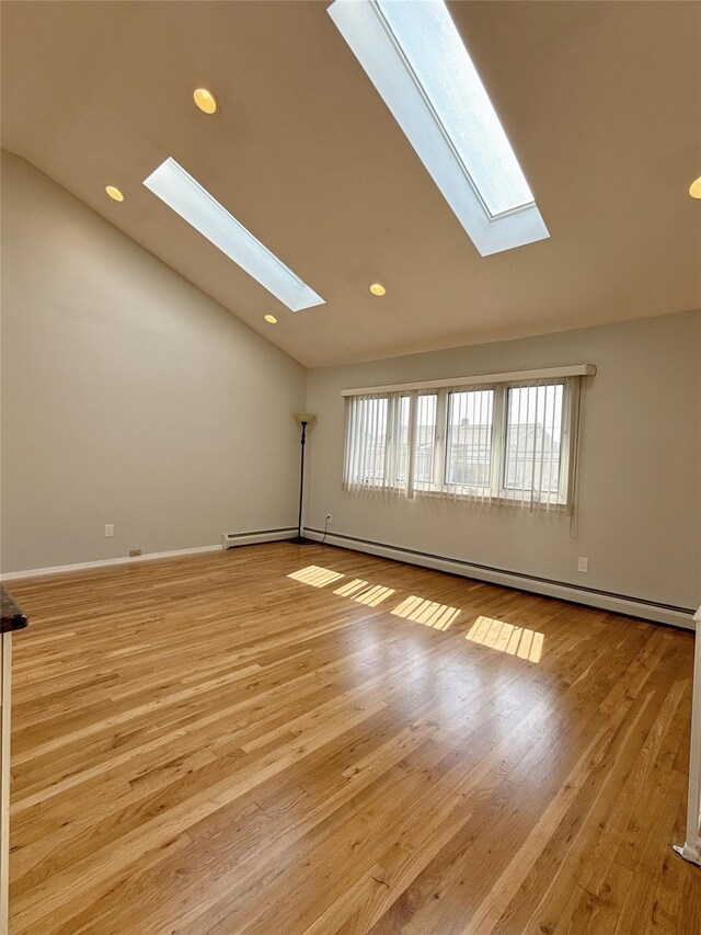bonus room featuring light wood finished floors, recessed lighting, vaulted ceiling with skylight, and a baseboard radiator