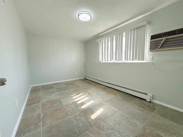 empty room with baseboards, stone finish flooring, a baseboard heating unit, and an AC wall unit
