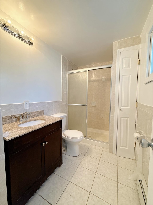bathroom featuring tile patterned floors, a shower stall, a baseboard heating unit, tile walls, and toilet