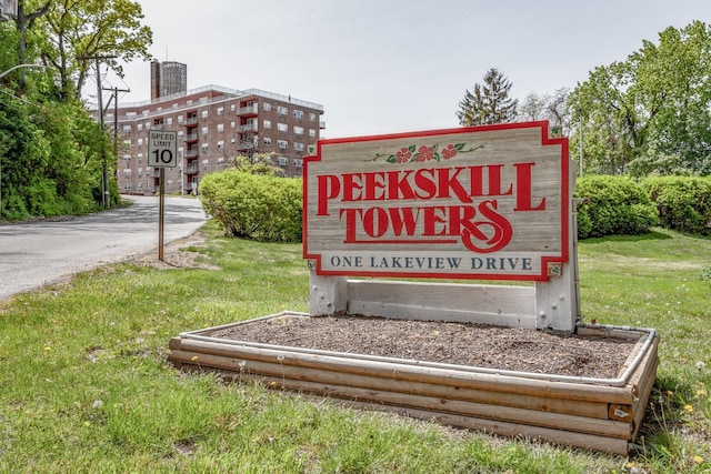 community / neighborhood sign featuring a lawn
