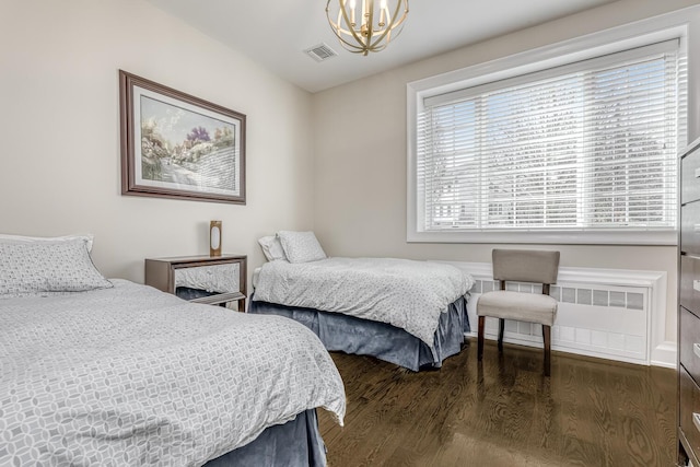 bedroom featuring dark wood-style floors, visible vents, an inviting chandelier, and radiator heating unit