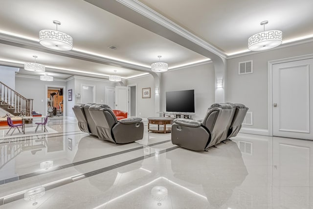 living area featuring visible vents, ornamental molding, and arched walkways