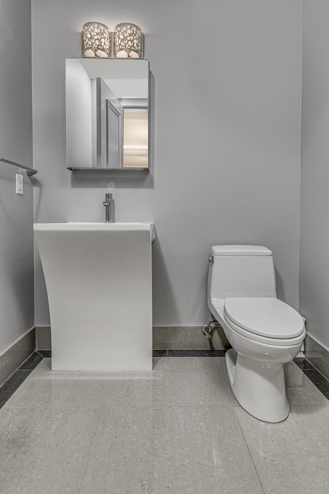bathroom with vanity, toilet, and baseboards