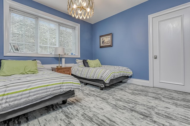 bedroom featuring a chandelier and baseboards