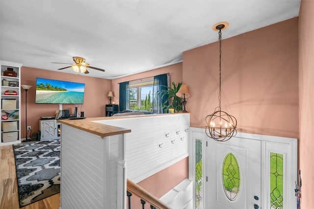 interior space with wood finished floors and ceiling fan with notable chandelier