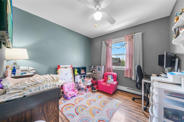bedroom featuring ceiling fan, baseboards, wood finished floors, and a baseboard radiator