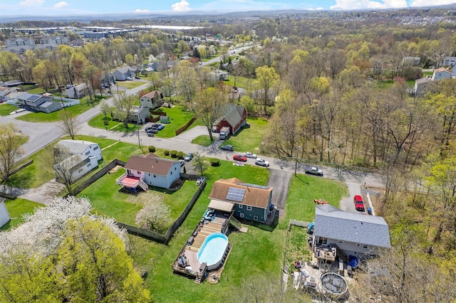 drone / aerial view featuring a wooded view and a residential view