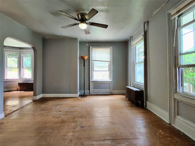 635 N Division St, Peekskill, NY 10566 - unfurnished room with ceiling fan, arched walkways, wood finished floors, baseboards, and radiator