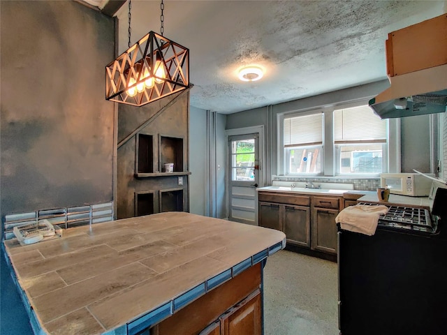 635 N Division St, Peekskill, NY 10566 - kitchen featuring pendant lighting, white microwave, and tile countertops