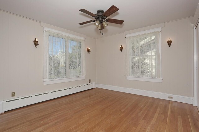 85 S Harrison Ave, Congers, NY 10920 - spare room with a healthy amount of sunlight, baseboard heating, a ceiling fan, and hardwood / wood-style floors