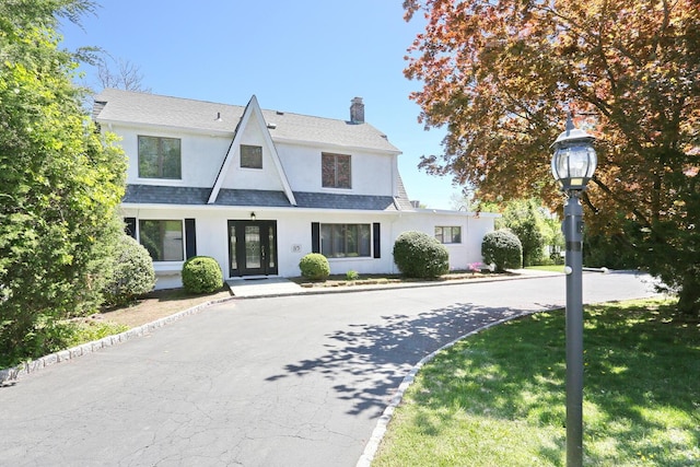 85 S Harrison Ave, Congers, NY 10920 - view of front of home with roof with shingles, stucco siding, a front yard, and a chimney