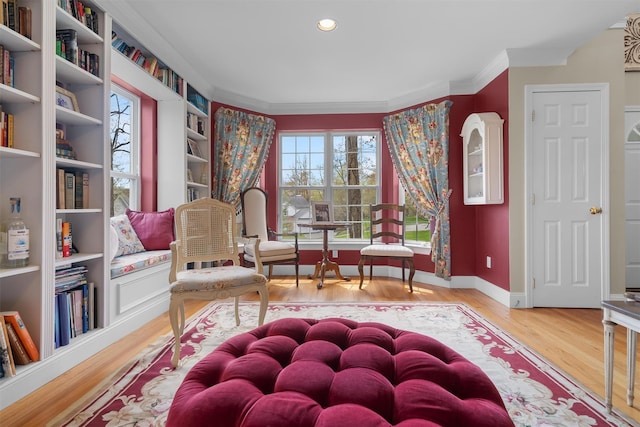 sitting room featuring baseboards, ornamental molding, recessed lighting, and wood finished floors