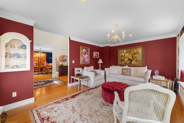 living room featuring crown molding, baseboards, wood finished floors, and a notable chandelier