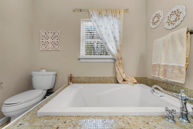 full bathroom featuring a garden tub and toilet