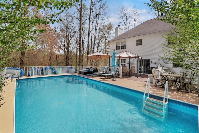 view of pool with a fenced in pool, fence, a patio, and a water slide