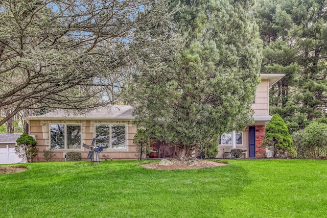 view of front facade with a front lawn and brick siding