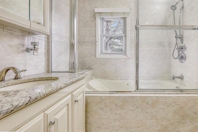 bathroom featuring vanity, tiled shower / bath, and tile walls