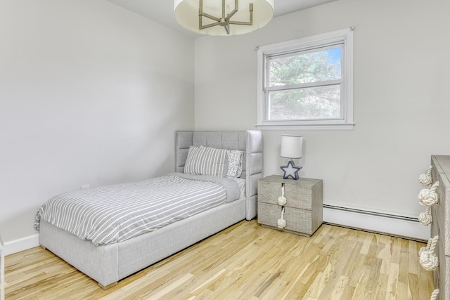 bedroom featuring wood finished floors and a baseboard radiator