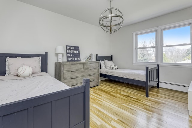bedroom with light wood-style floors, a notable chandelier, and baseboard heating