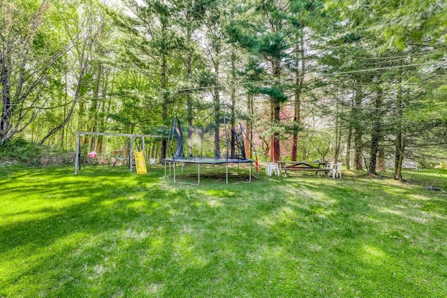 view of yard with a playground and a trampoline