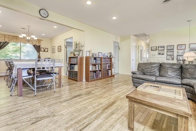 living room with recessed lighting, an inviting chandelier, and wood finished floors