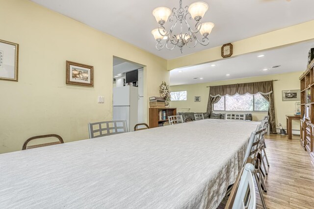 dining room featuring a chandelier, recessed lighting, and light wood finished floors