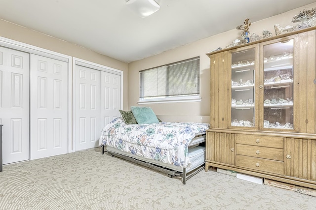 carpeted bedroom featuring multiple closets
