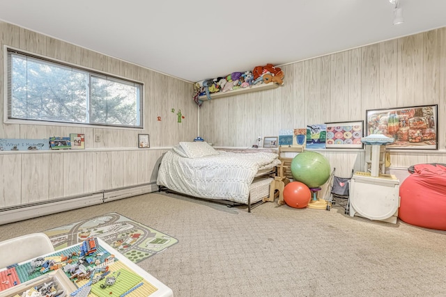 carpeted bedroom with baseboard heating and wood walls