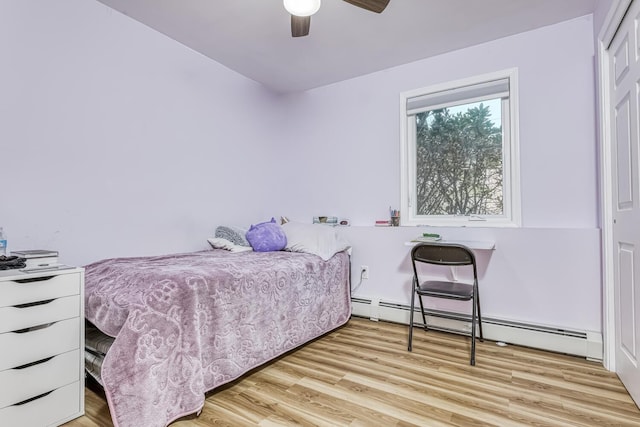 bedroom featuring wood finished floors and a baseboard radiator