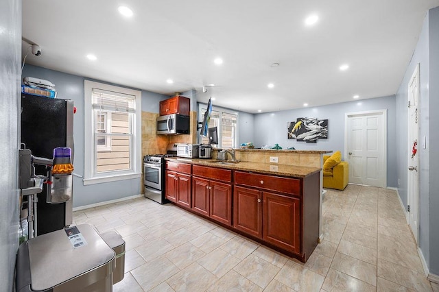 26-18 92nd St, East Elmhurst, NY 11369 - kitchen with appliances with stainless steel finishes, a sink, a peninsula, healthy amount of natural light, and recessed lighting
