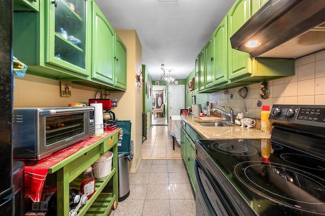 26-18 92nd St, East Elmhurst, NY 11369 - kitchen featuring range with electric stovetop, green cabinets, under cabinet range hood, a sink, and tasteful backsplash