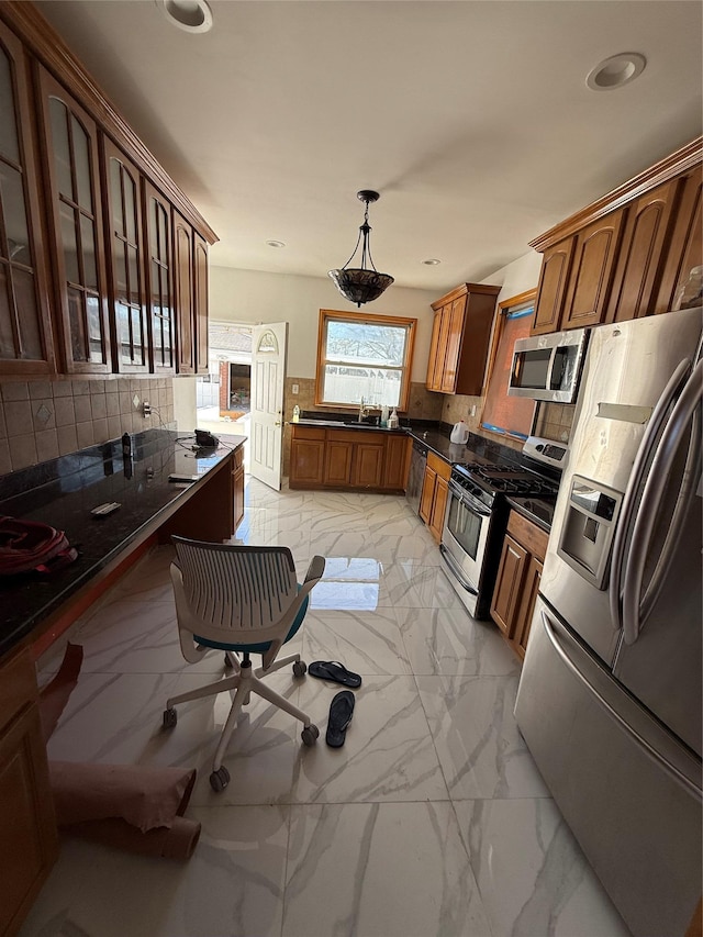 kitchen with a sink, dark countertops, appliances with stainless steel finishes, and marble finish floor