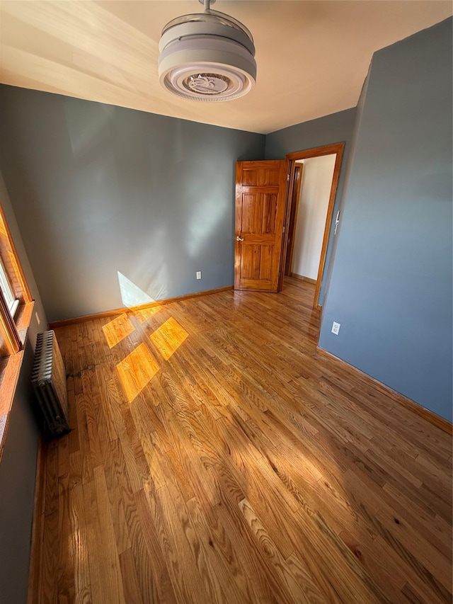 unfurnished room with wood finished floors and baseboards
