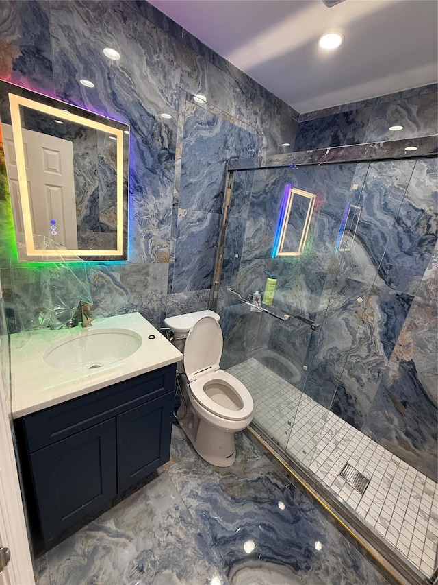 bathroom with vanity, toilet, marble finish floor, and a marble finish shower