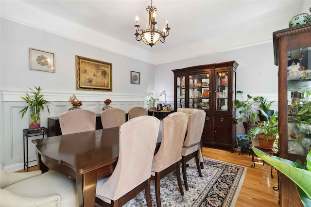 243 W 98th St Unit 2C, New York Manhattan, NY 10025 - dining room featuring light wood finished floors, a wainscoted wall, and a notable chandelier