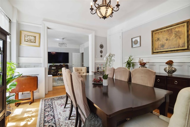 243 W 98th St Unit 2C, New York Manhattan, NY 10025 - dining area with an inviting chandelier, light wood-style flooring, and a decorative wall