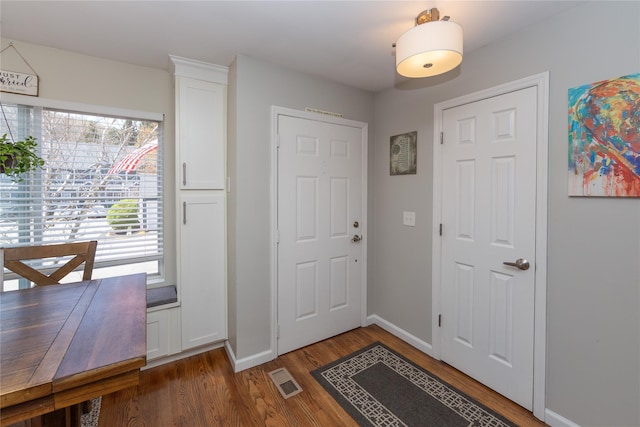 entryway with wood finished floors, visible vents, and baseboards