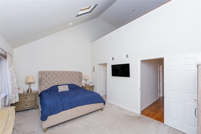 bedroom featuring a skylight, visible vents, high vaulted ceiling, and carpet flooring