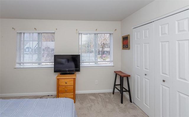 carpeted bedroom featuring baseboards and a closet