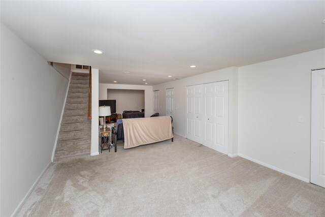 carpeted living area featuring baseboards, recessed lighting, and stairs