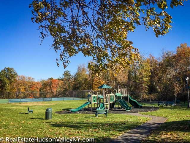 community play area with fence and a yard
