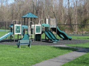 community play area featuring a lawn and fence