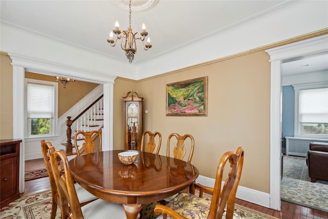 dining area featuring light wood-style flooring, a chandelier, a healthy amount of sunlight, and stairway