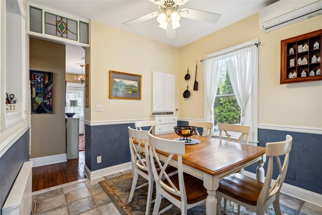 dining space with baseboards, a wall mounted air conditioner, and a ceiling fan