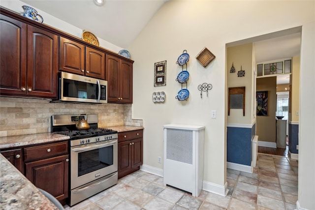 kitchen featuring tasteful backsplash, light stone countertops, baseboards, lofted ceiling, and stainless steel appliances