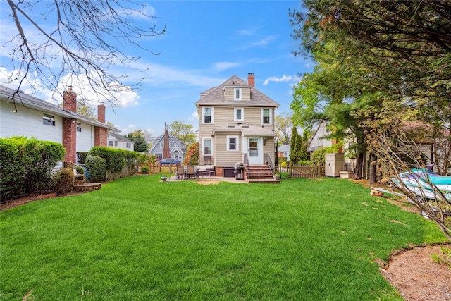 back of house with a lawn, a chimney, and a fenced backyard