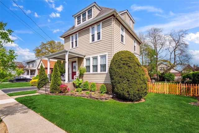 traditional style home featuring fence and a front lawn